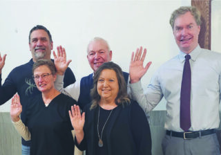 five people waving at the camera