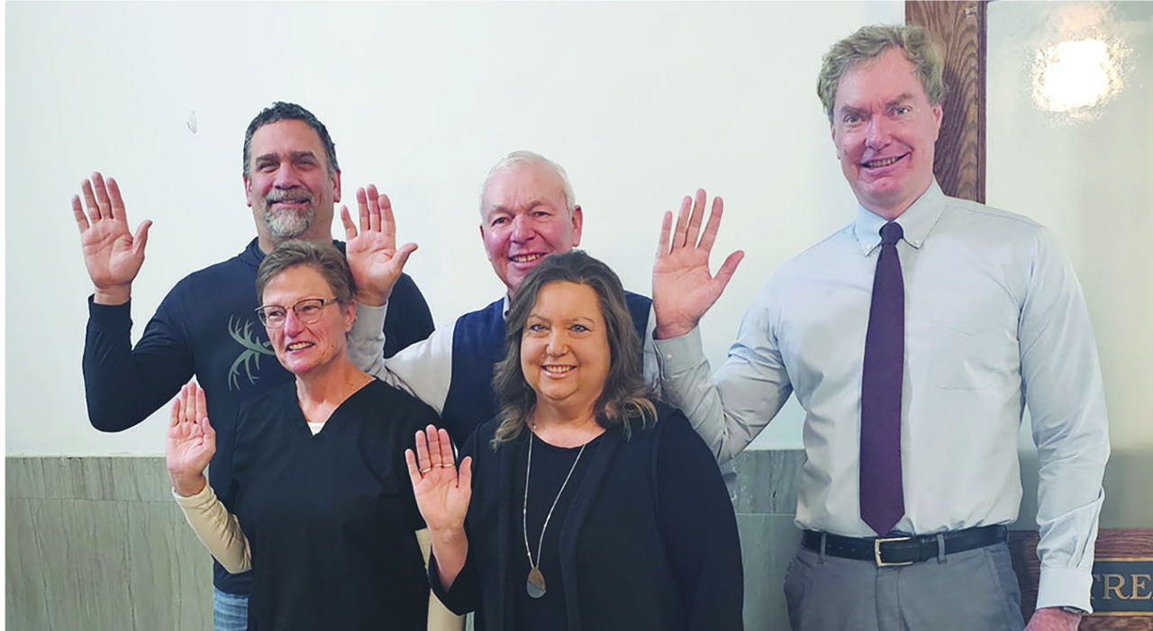 five people waving at the camera