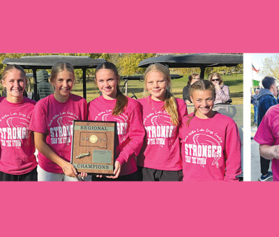 seven teens in hot pink shirts lined up with plaque