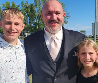 father posing with two children, a boy and a girl on each side of him