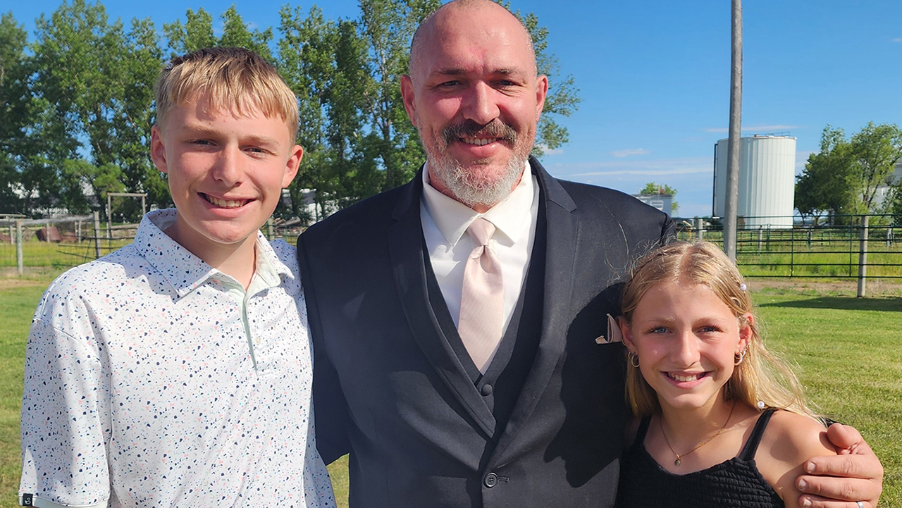 father posing with two children, a boy and a girl on each side of him