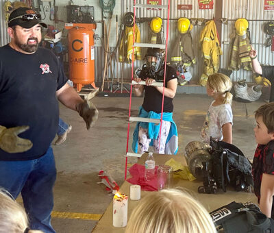 firefighter speaking to children in fire hall