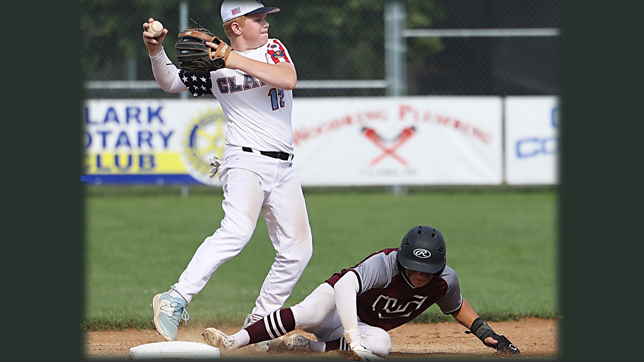 young teenage baseball player throwing a ball after getting the player at his feet out