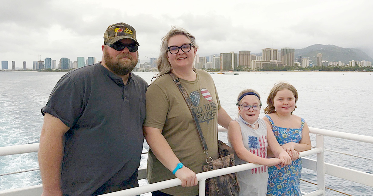 Waldow family along railing with water in background