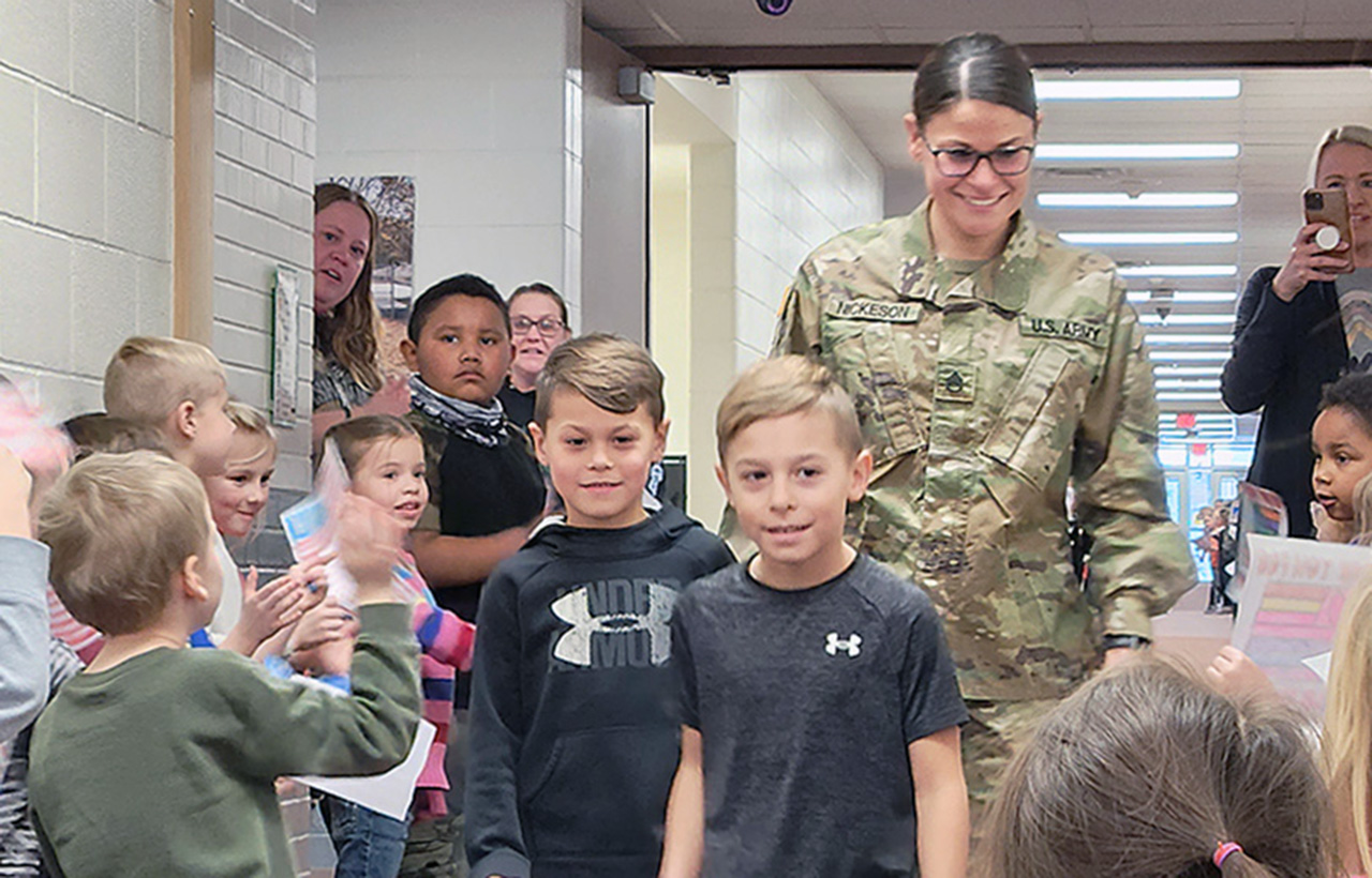 amber nickeson in uniform walking behind two students