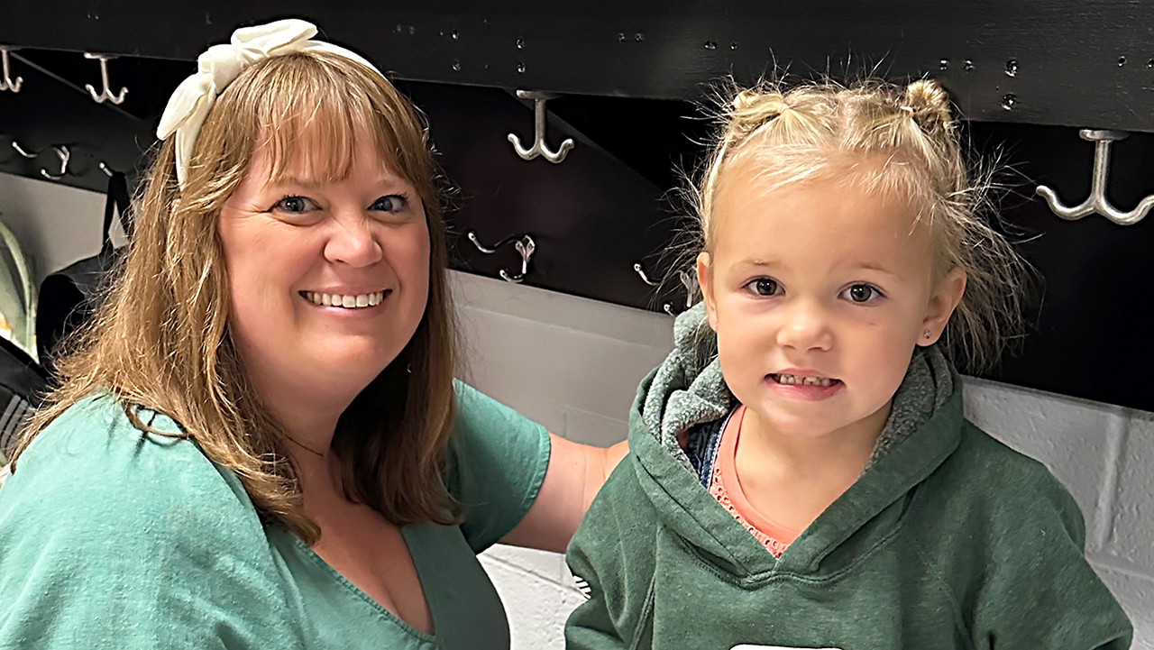 adult and young child both in green tops