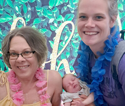 two women posing with a baby