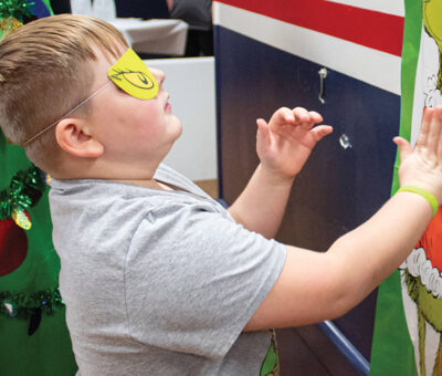 young boy pinning the heart on the grinch