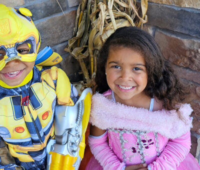 a young boy and girl dressed in superhero and princess costumes