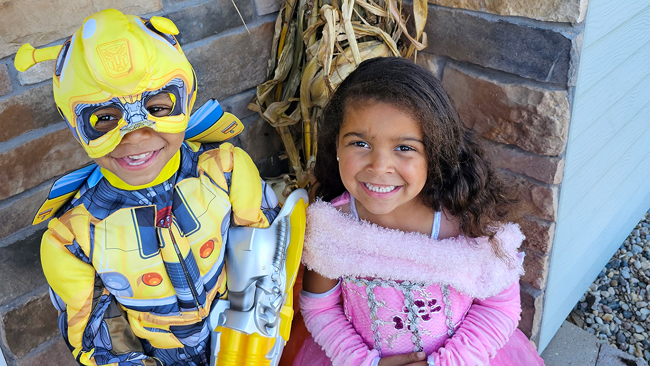 a young boy and girl dressed in superhero and princess costumes