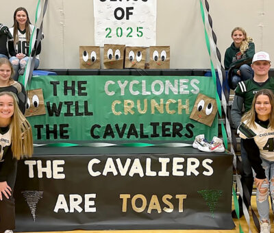 Willow Lake juniors posed next to homecoming signs that say "The Cavaliers are toast" on the bottom and "The Cyclones will crunch the Cavaliers" on top