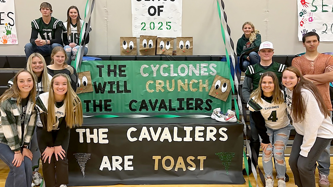 Willow Lake juniors posed next to homecoming signs that say "The Cavaliers are toast" on the bottom and "The Cyclones will crunch the Cavaliers" on top