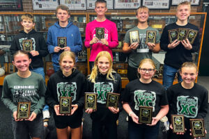 cross country athletes posing with plaques