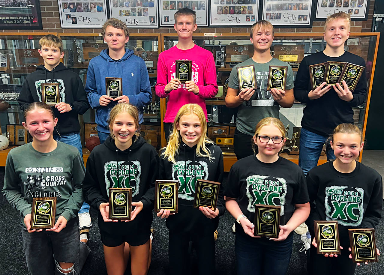 cross country athletes posing with plaques